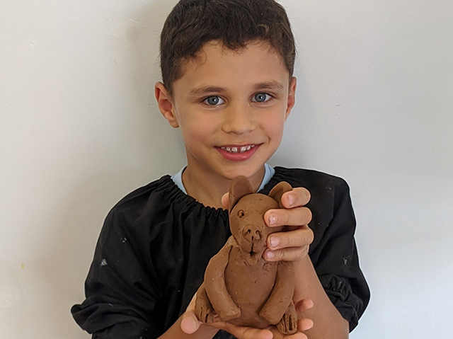 Kidz Artworx boy holding clay sculpture