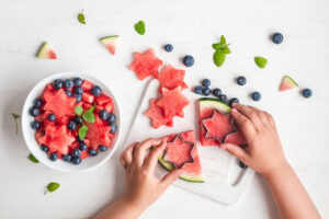 Child cutting watermelon shapes